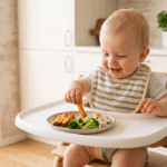 Bebé comiendo en la trona recetas ricas en hierro para bebés