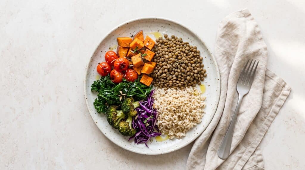 Plato con lentejas, arroz integral y verduras, ejemplo de comida para un embarazo vegetariano